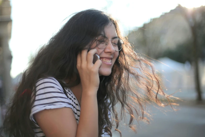 a woman with glasses talking on a cell phone, a picture, pexels, teen girl, hispanic, stringy, 1 4 9 3