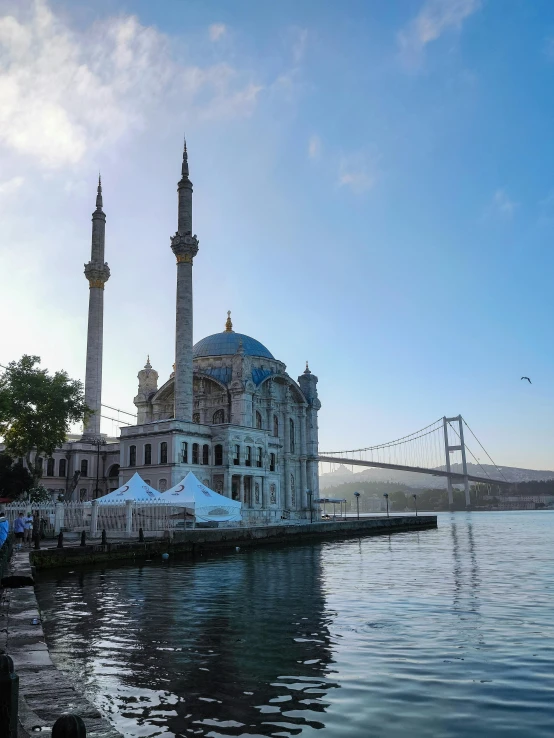a large building sitting next to a body of water, inspired by Niyazi Selimoglu, hurufiyya, with beautiful mosques, neoclassical architecture, 🚿🗝📝, tourist destination