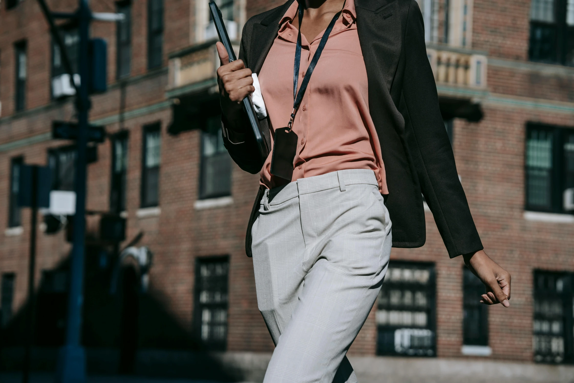 a woman walking down a street holding a tennis racket, by Nina Hamnett, trending on pexels, office clothes, brown pants, outfit: cop, schools