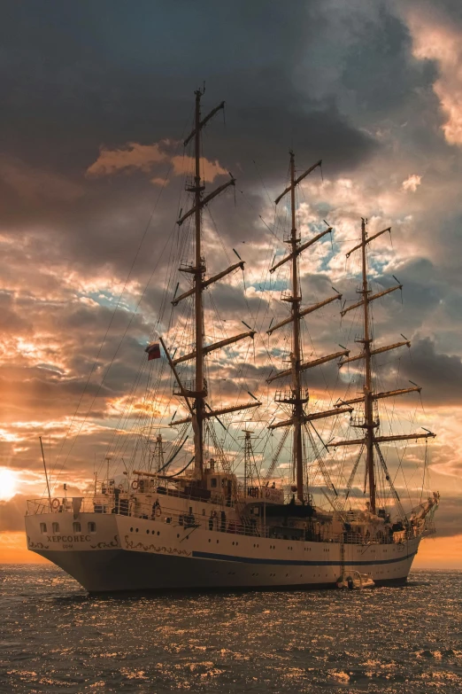 a large boat floating on top of a body of water, by Adam Marczyński, pexels contest winner, romanticism, three masts, sunset with cloudy skies, square, chile