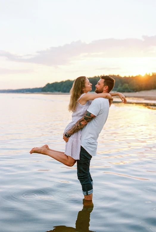 a man and a woman are standing in the water, a photo, pexels contest winner, romanticism, hugging her knees, summer setting, excited, tattooed