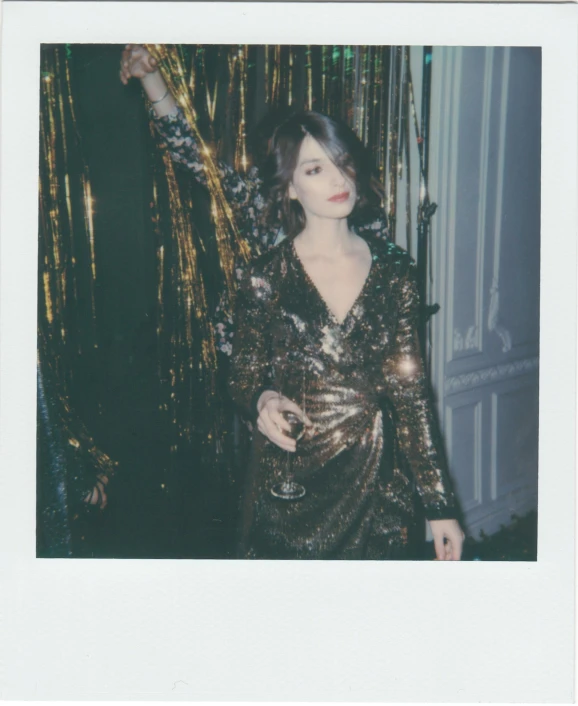 a polaroid picture of a woman in a gold dress, inspired by Elsa Bleda, unsplash, holography, finn wolfhard, new years eve, glam rockers drinking wine, song hye - kyo