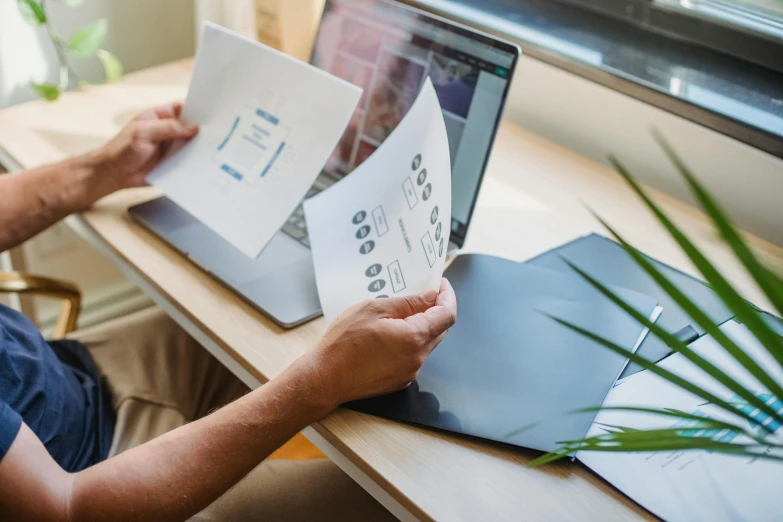 a man sitting at a desk using a laptop computer, a picture, by Adam Marczyński, pexels contest winner, layered paper style, 9 9 designs, technical document, fresh from the printer