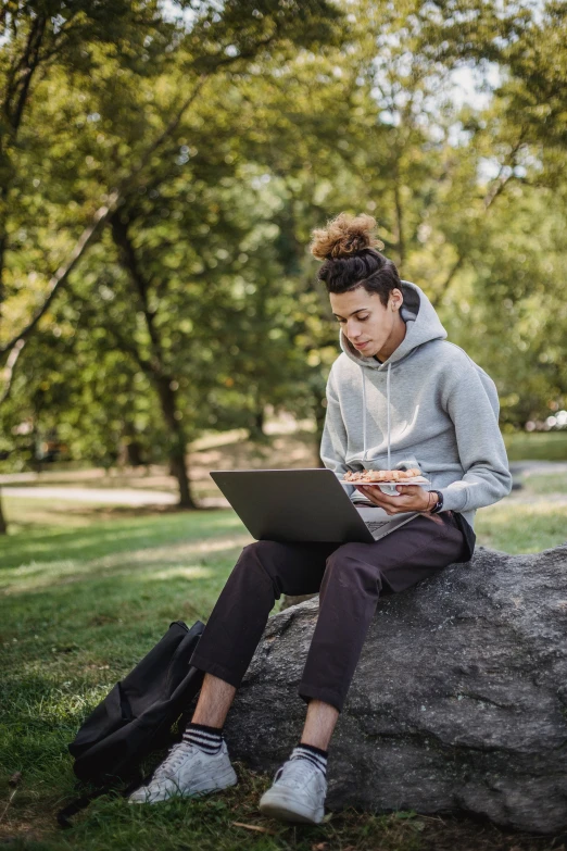 a man sitting on a rock using a laptop, queer woman, college, getty images, parks