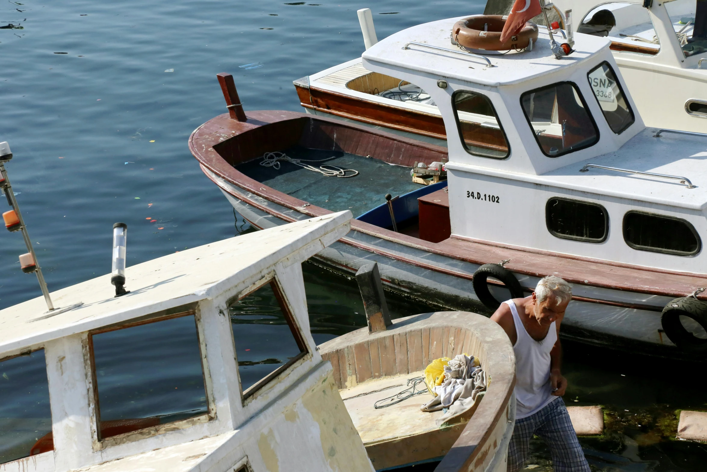 a couple of boats that are sitting in the water, by Patrick Pietropoli, pexels contest winner, old man doing hard work, white, maintenance photo, youtube thumbnail