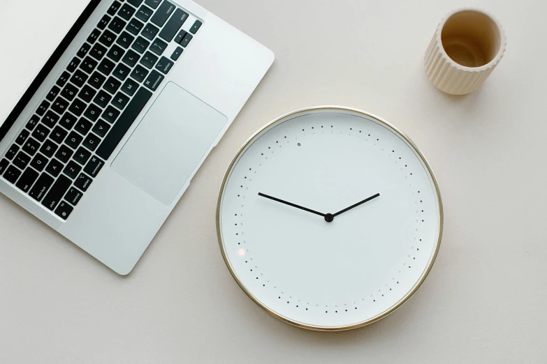 a white clock sitting next to a laptop computer, trending on pexels, minimalism, gold and white, circular, very large, two