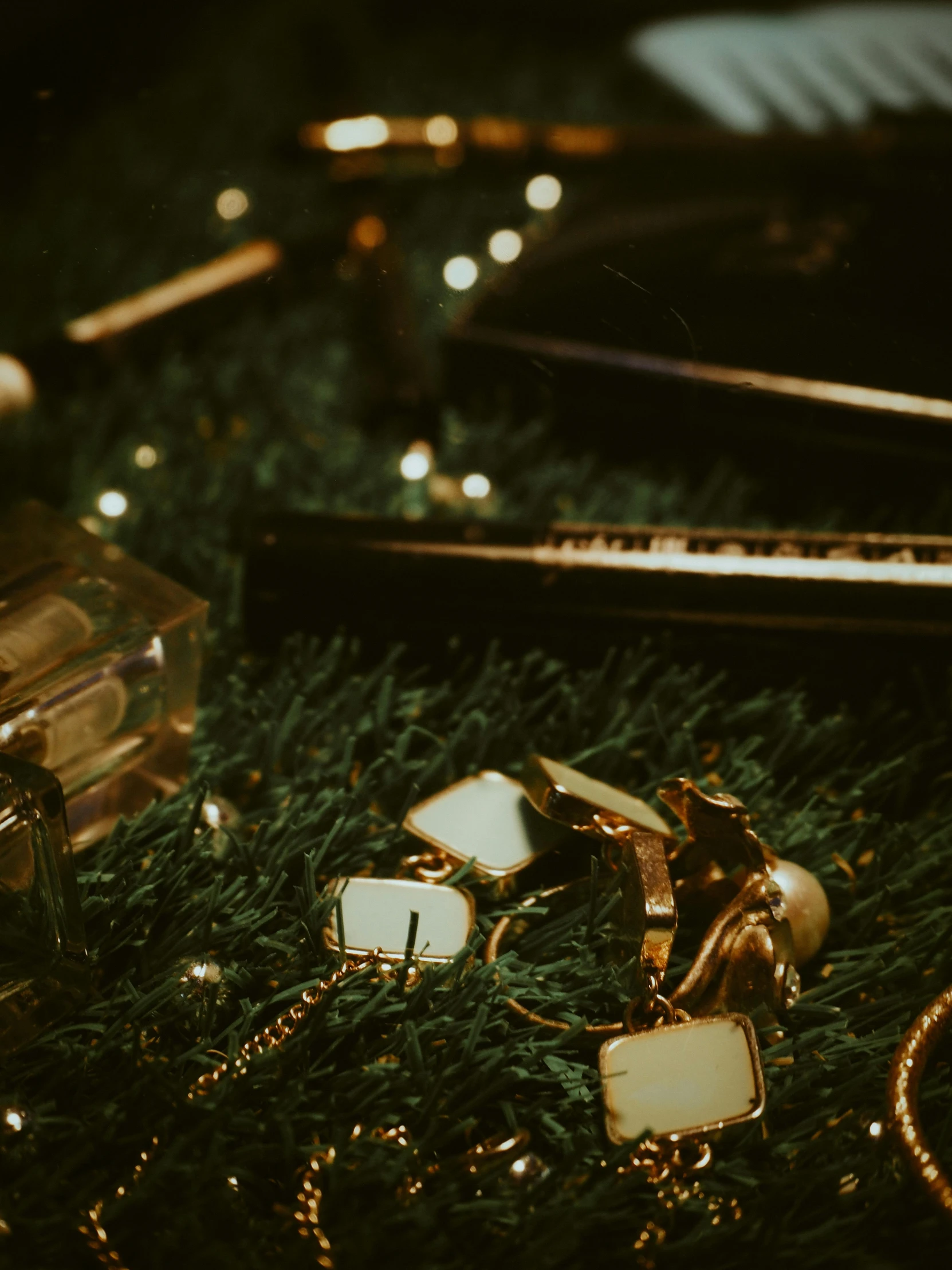 a pile of jewelry sitting on top of a lush green field, inspired by Elsa Bleda, trending on pexels, christmas night, gold glasses, dark and moody aesthetic, golden miniatures