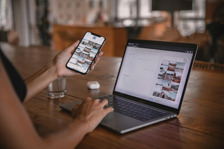 a person sitting at a table with a laptop and a cell phone, a picture, trending on pexels, award winning webdesign, 9 9 designs, taken in the early 2020s, creative coder with a computer