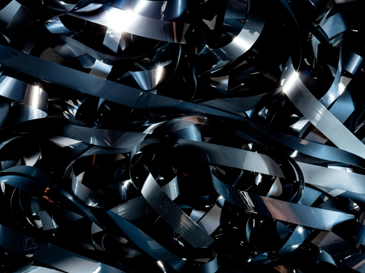 a close up of a bunch of black and silver ribbons, an album cover, unsplash, plasticien, all dark blue metal, stainless steal, twisted shapes, 3 4 5 3 1