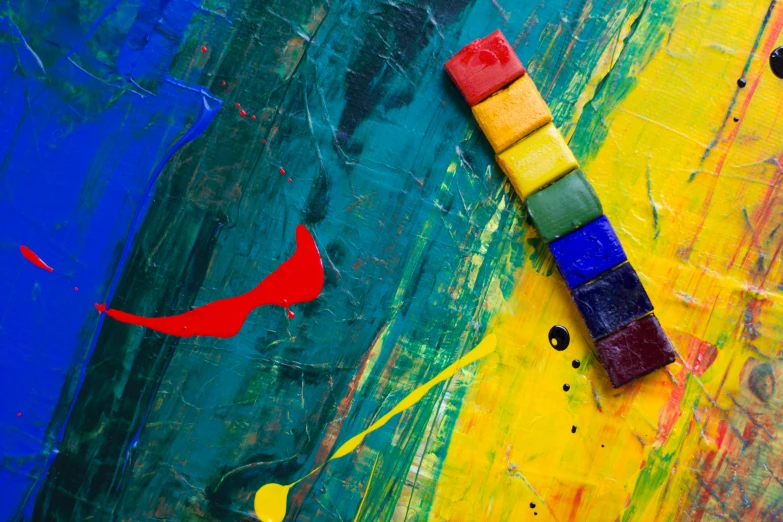 a close up of a piece of art on a table, inspired by Hans Hofmann, pexels contest winner, building blocks, grungy; colorful, blue and yellow, plasticine