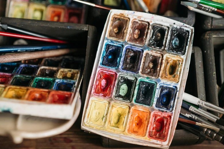 a box of watercolor paints sitting on top of a wooden table, inspired by Kyffin Williams, trending on unsplash, 🎨🖌️, thumbnail, model painting, burnt umber