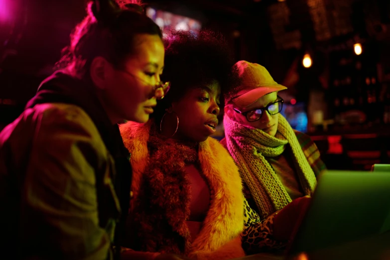 a group of people sitting in front of a laptop computer, pexels, afrofuturism, chinatown bar, three women, warm coloured, f / 2 0