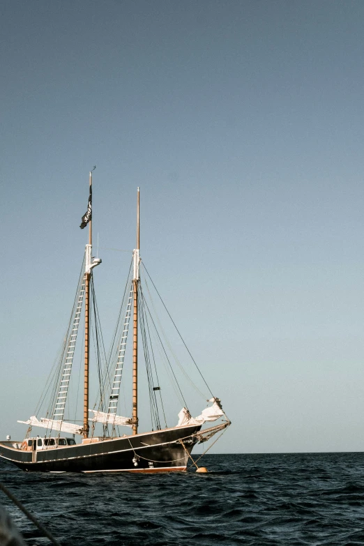 a large boat floating on top of a body of water, a portrait, sailboats in the water, daytime, stacked image, square