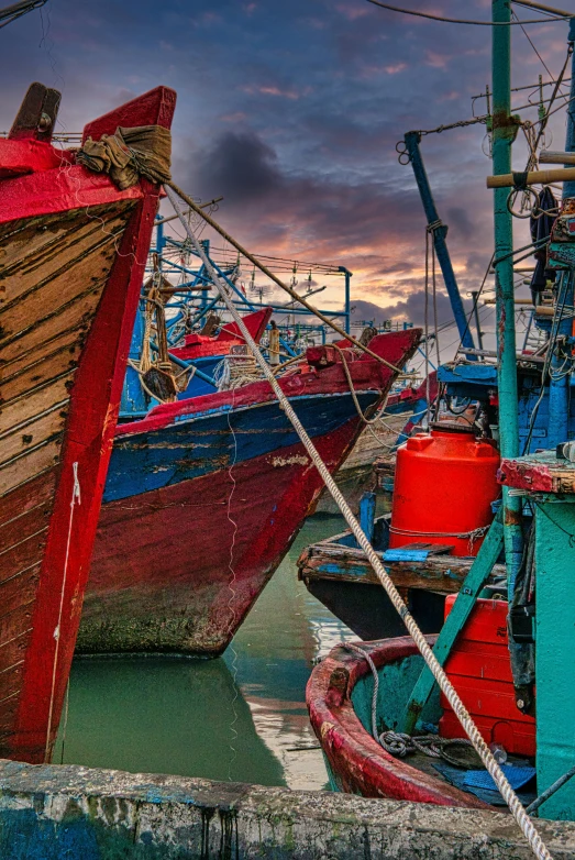 a couple of boats that are sitting in the water, inspired by Steve McCurry, pexels contest winner, colorful with red hues, shipping docks, morocco, intense dramatic hdr