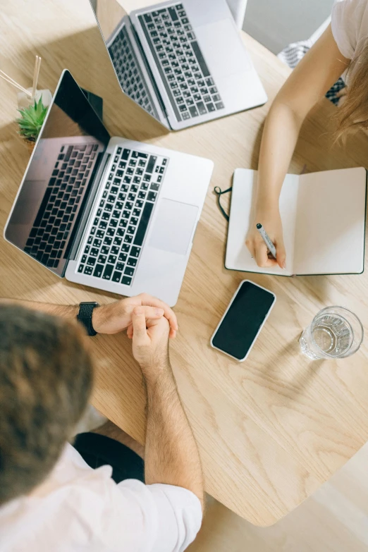 a couple of people sitting at a table with laptops, by Dan Content, trending on pexels, renaissance, top-down shot, 9 9 designs, office background, behance lemanoosh