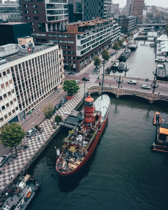 a river filled with lots of boats next to tall buildings, a photo, by Jan Tengnagel, pexels contest winner, victorian fire ship, high angle shot, helmond, thumbnail