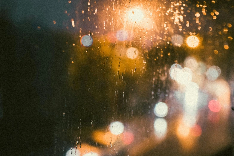 a close up of a window with rain on it, inspired by Elsa Bleda, trending on unsplash, streetlights, autumn lights, light particles, tear drops