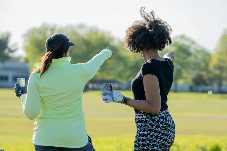 a couple of women standing on top of a lush green field, wrx golf, dabbing, tx, practice