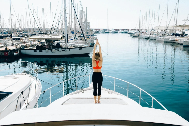 a woman is standing on the bow of a boat, pexels contest winner, marjaryasana and bitilasana, harbour, profile image, thumbnail