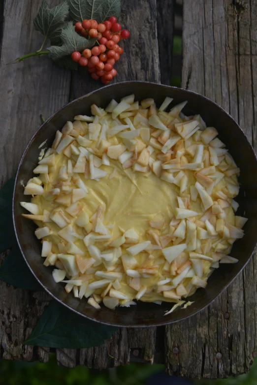 a pan of food sitting on top of a wooden table, hurufiyya, blonde cream, apple, medium, très détaillé