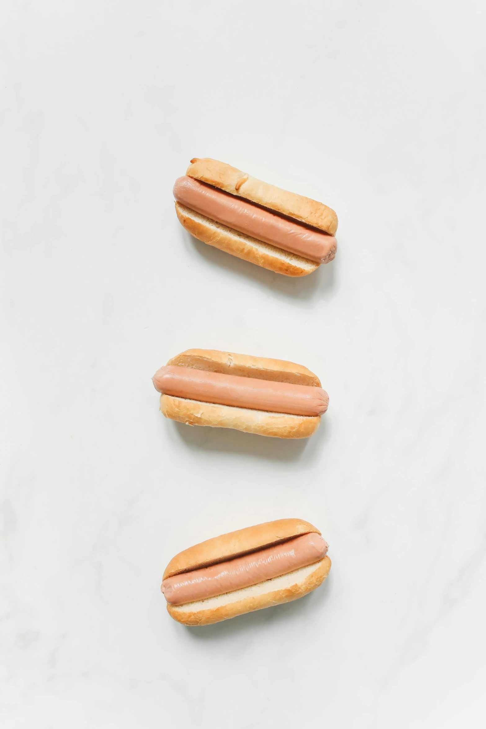 a group of hot dogs sitting on top of a white counter, a portrait, unsplash, 3 - piece, flat lay, smooth texture, light tan