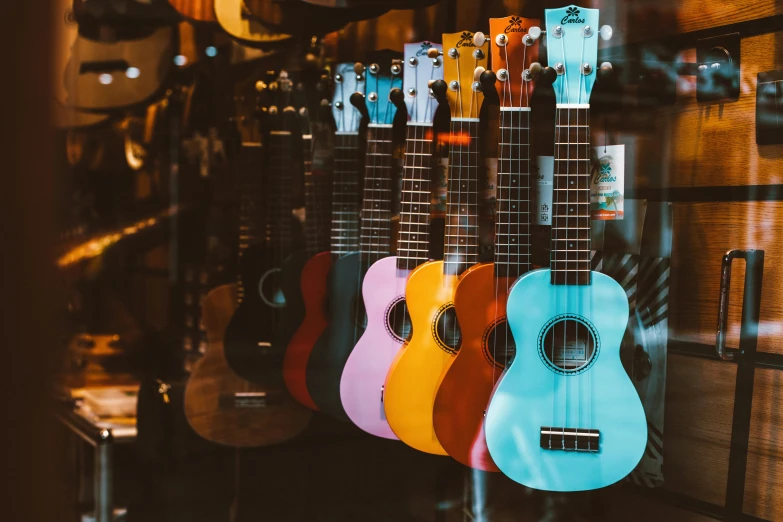 a row of colorful guitars hanging on a wall, pexels contest winner, hurufiyya, ukulele, thumbnail, 🚿🗝📝, blurred background