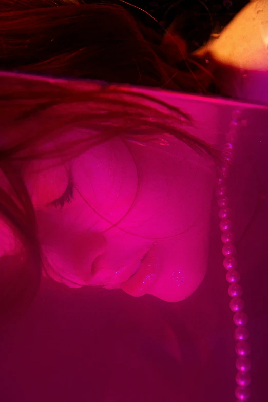 a woman laying down with a cell phone in her hand, a hologram, inspired by Nan Goldin, flickr, glowing magenta face, submerged underwater, hibernation capsule close-up, rich deep pink