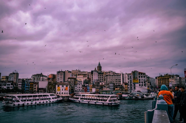 a group of people standing on top of a pier next to a body of water, a colorized photo, pexels contest winner, hurufiyya, purple roofs, istanbul, flying ships in the background, youtube thumbnail