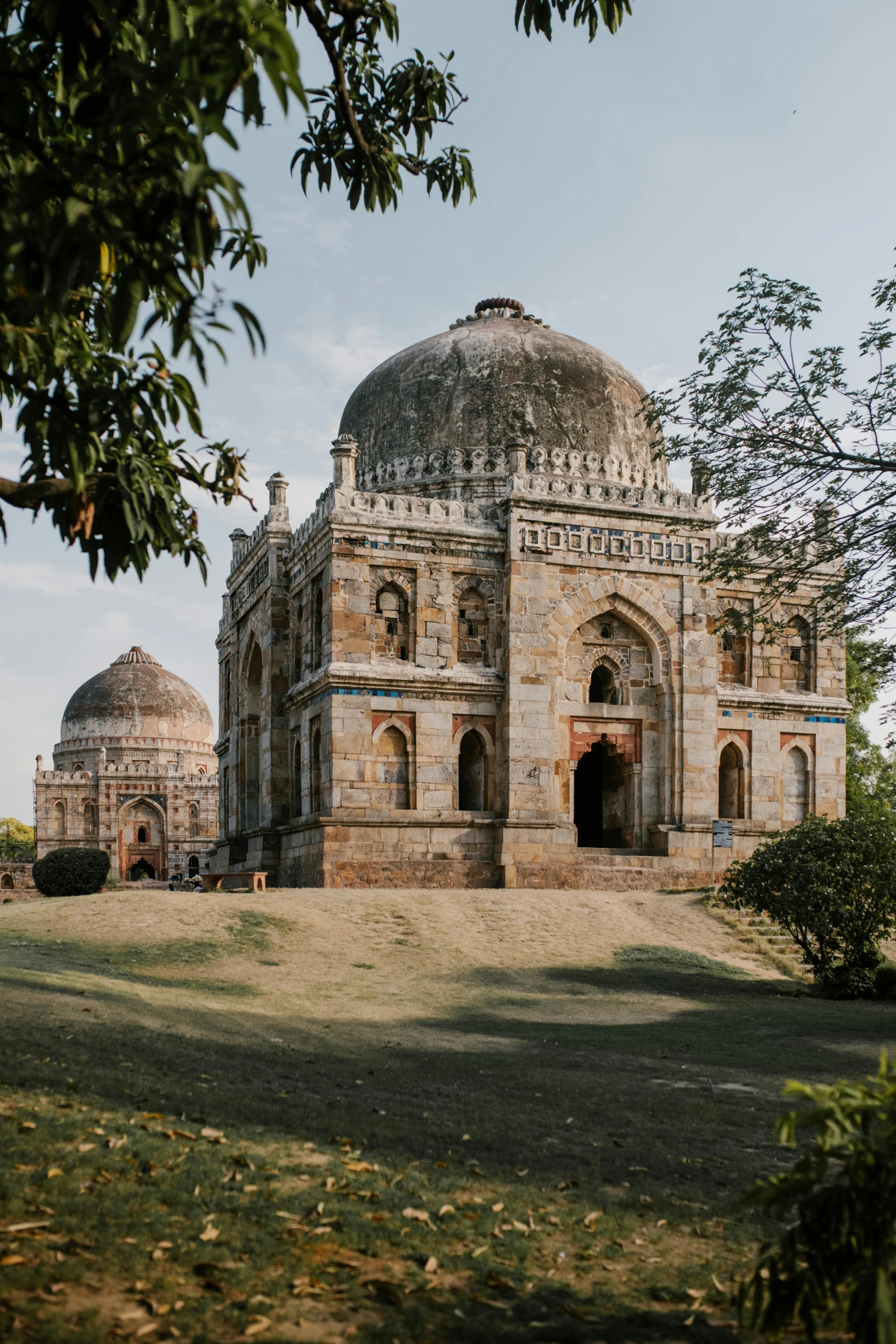 a large building sitting on top of a lush green field, a colorized photo, pexels contest winner, with great domes and arches, madhubani, tomb, taken in the early 2020s