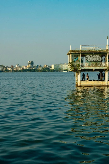 a boat sitting on top of a body of water, calcutta, lookout tower, partly sunken! in the lake!, small dock