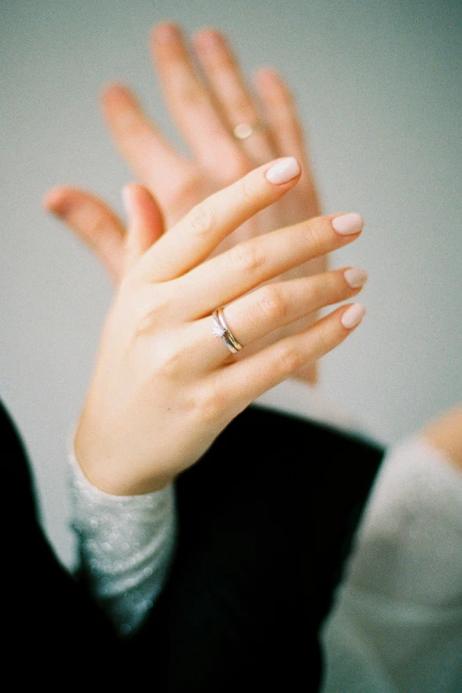 a close up of a person with a ring on their finger, by Nina Hamnett, waving hands, nordic wedding ring, **cinematic, tall