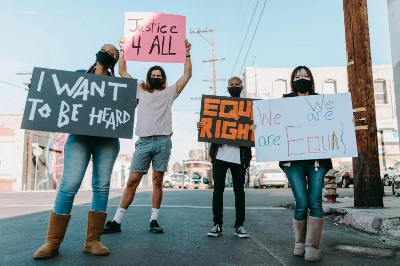 a group of people holding signs in the street, by Carey Morris, pexels, polychromatic, kailee mandel, profile image, justice