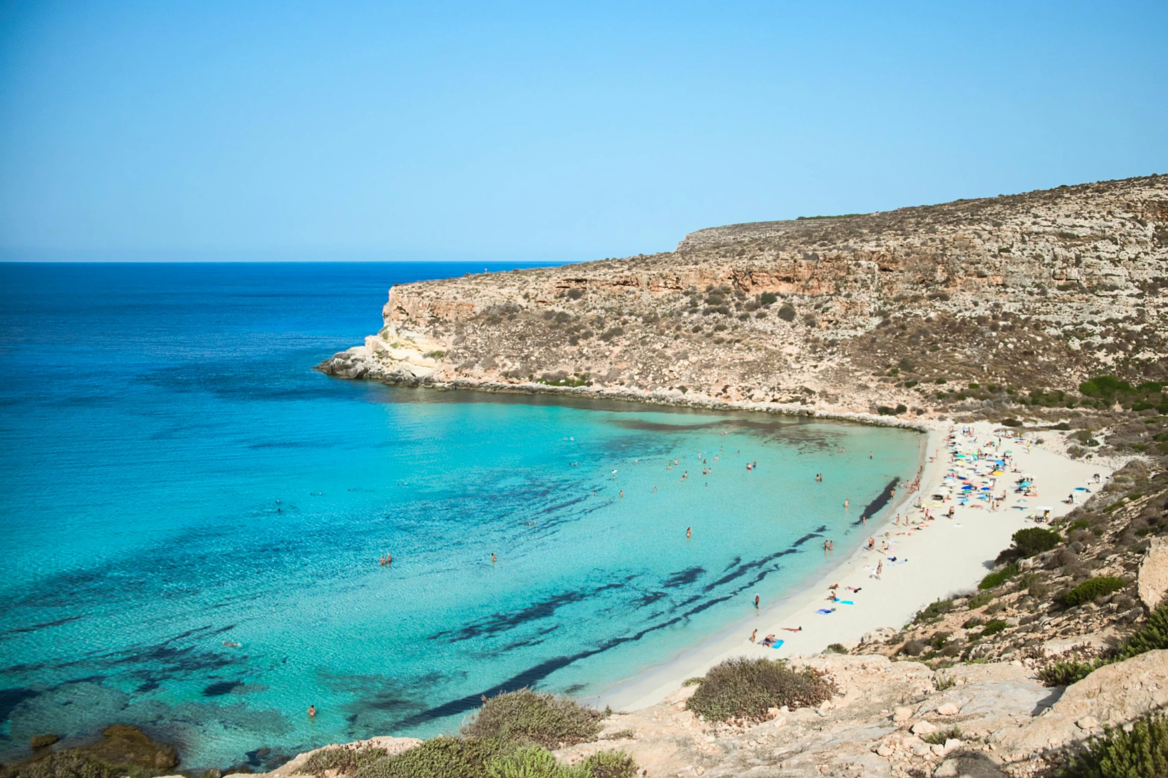 a large body of water next to a sandy beach, pexels contest winner, les nabis, med bay, light blue water, thumbnail, christina kritkou