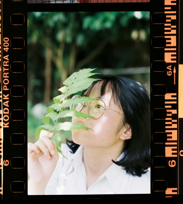 a woman holding a plant in front of her face, a polaroid photo, by Tan Ting-pho, unsplash, garden behind the glasses, 3 5 mm!!!!! lens, vhs filter, 8k octan photo