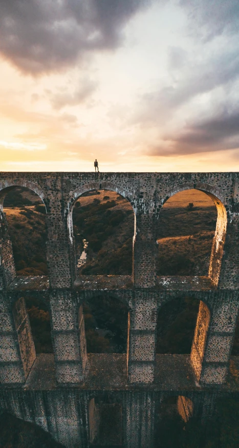 a person standing on top of a bridge, pexels contest winner, renaissance, aqueducts, tall windows, unsplash 4k, well built