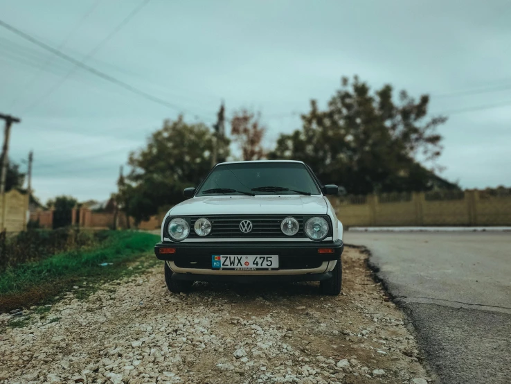 a white car parked on the side of a road, by Adam Marczyński, unsplash contest winner, photorealism, 80s nostalgia, wrx golf, portrait of a old, romanian