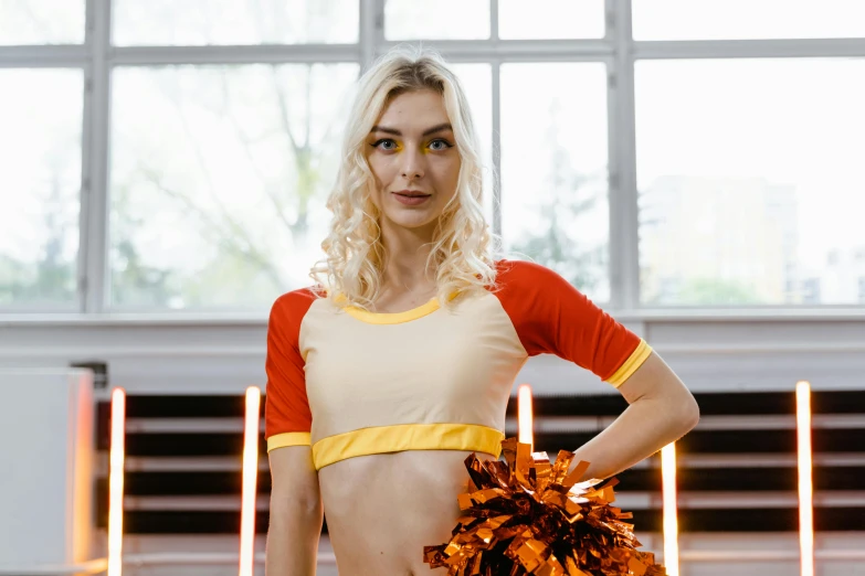 a woman in a cheerleader outfit holding a pom pom, pexels contest winner, white and orange breastplate, indoor picture, alexey egorov, lycra costume