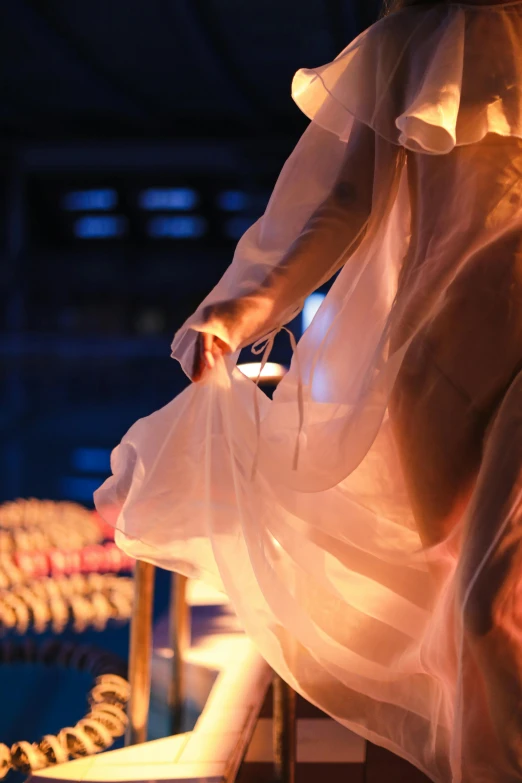 a woman in a white dress standing on a ledge, happening, warm lantern lighting, poolside, olympics ceremony, draped in transparent cloth