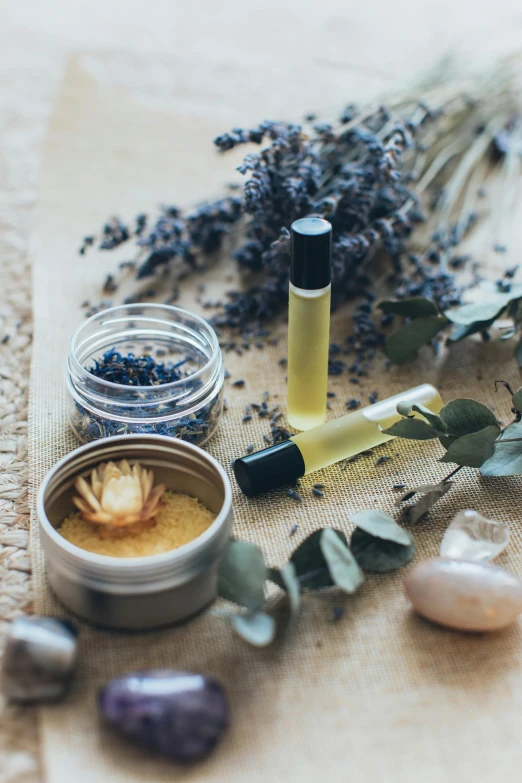 a bunch of different items sitting on top of a table, a still life, trending on pexels, healing tubes, lavender, intricate oil, natural makeup