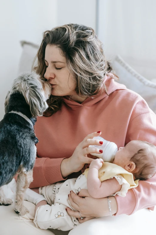 a woman sitting on a couch holding a baby and a dog, pexels contest winner, renaissance, kissing each other, manuka, milk, profile image