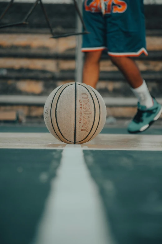 a basketball ball sitting on top of a basketball court, on ground