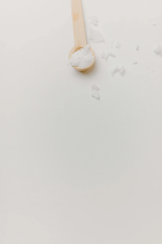 a toothbrush sitting on top of a white surface, by Matthias Stom, trending on unsplash, postminimalism, powdered sugar, rice, animation, white petal