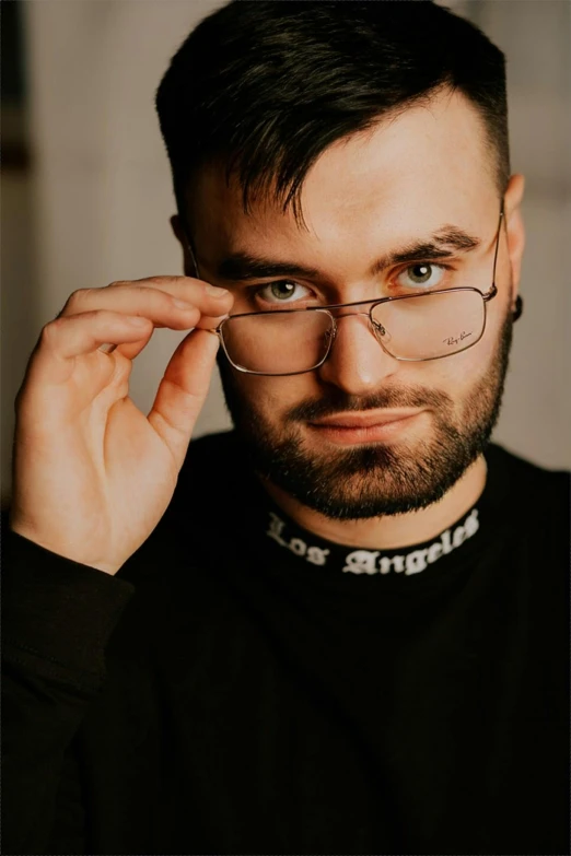 a close up of a person wearing glasses, an album cover, inspired by Ion Andreescu, trending on reddit, photorealism, with a beard and a black shirt, dramatic smirk pose, lush vista, professional profile picture