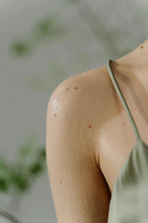 a close up of a woman brushing her teeth, a tattoo, by Adam Marczyński, trending on pexels, renaissance, covered in water drops, showing her shoulder from back, natural skin tone 4k textures, green skin with scales