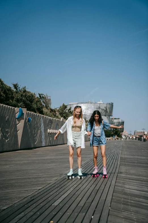 two young girls riding skateboards on a boardwalk, trending on unsplash, medium format, new jersey, attractive photo, tourist photo