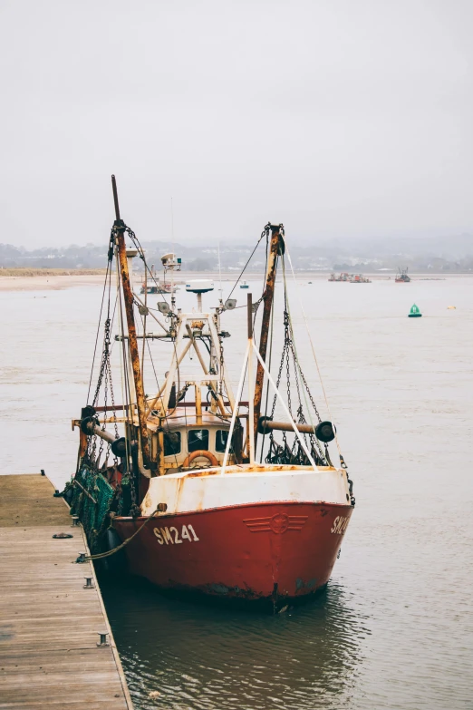 a red and white boat sitting on top of a body of water, by Daniel Seghers, pexels contest winner, fish seafood markets, maryport, big graphic seiner ship, slight overcast