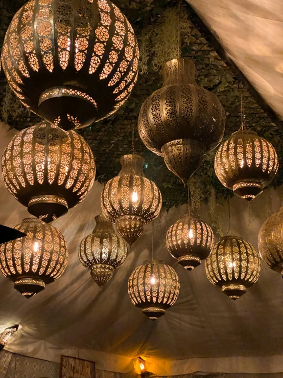 a room filled with lots of lamps hanging from the ceiling, arabesque, gold dappled lighting, outdoor lighting, instagram story, exotic