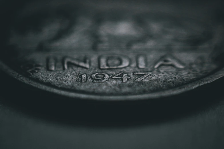 a close up of a coin on a table, an etching, pexels contest winner, indian, wartime footage, low depth field, made of rubber