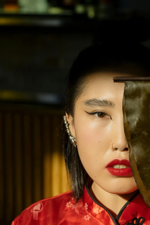 a woman holding a knife in front of her face, an album cover, inspired by Wu Bin, trending on pexels, surrealism, pat mcgrath, portrait of a geisha, reflection, fashion portrait
