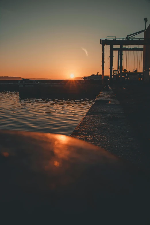 the sun is setting over a body of water, by Sebastian Spreng, docked at harbor, full frame image, **cinematic, multiple stories